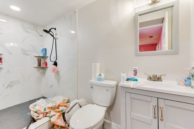 bathroom featuring tiled shower, vanity, and toilet