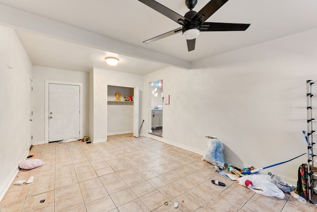 tiled spare room featuring beam ceiling and ceiling fan