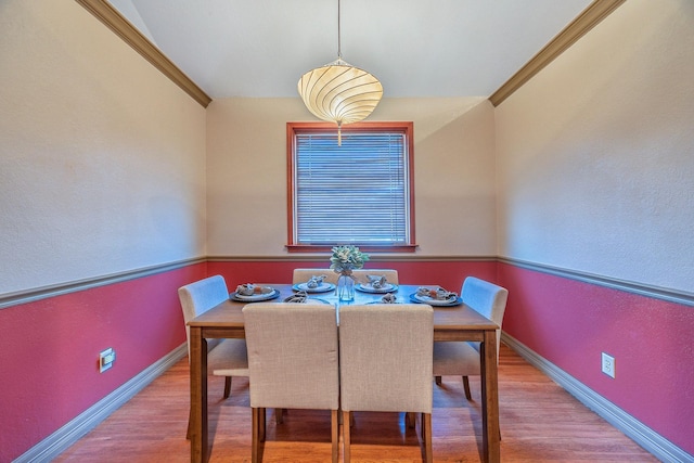 dining room with light hardwood / wood-style flooring and ornamental molding