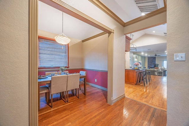 dining room with ornamental molding, hardwood / wood-style flooring, ceiling fan, and lofted ceiling