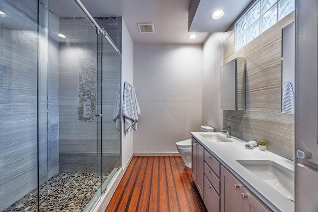 bathroom featuring an enclosed shower, vanity, toilet, and wood-type flooring