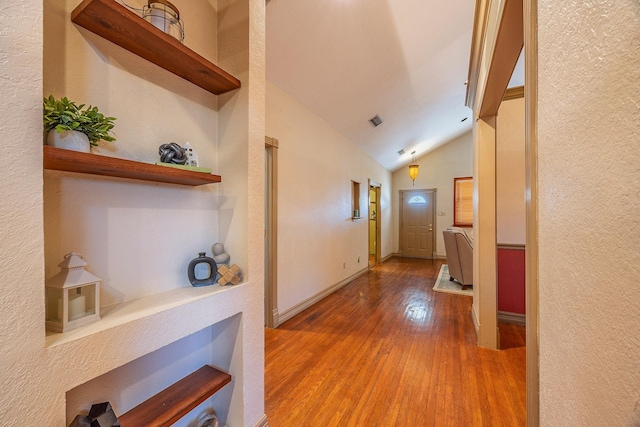 corridor featuring lofted ceiling and hardwood / wood-style flooring