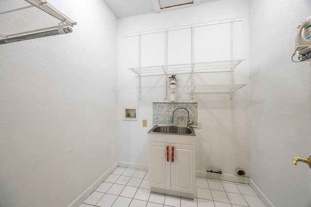 washroom featuring washer hookup, cabinets, light tile patterned floors, and sink