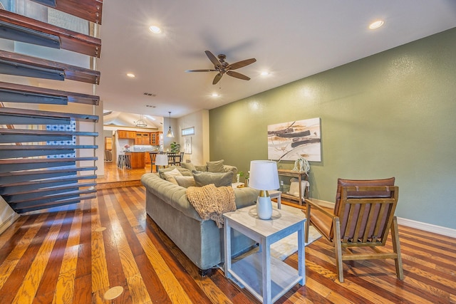 living room with ceiling fan and dark wood-type flooring