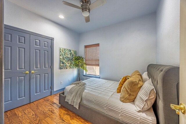 bedroom with wood-type flooring, a closet, and ceiling fan