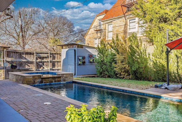 view of pool with an outdoor structure and an in ground hot tub