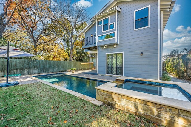 view of pool with a lawn and an in ground hot tub