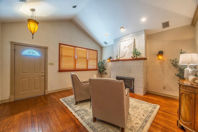 dining area with dark hardwood / wood-style floors, lofted ceiling, and a fireplace