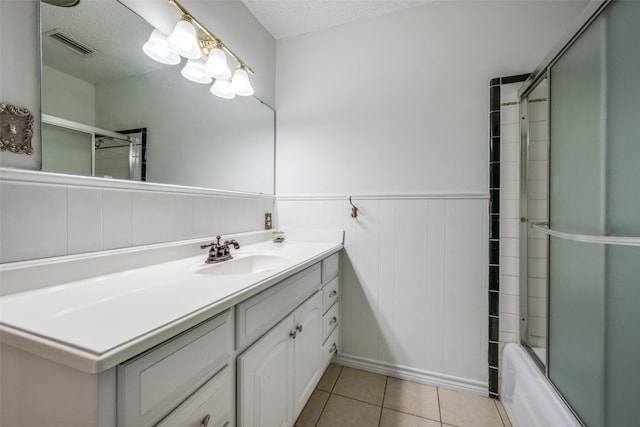 bathroom featuring vanity, a textured ceiling, tile patterned floors, and combined bath / shower with glass door