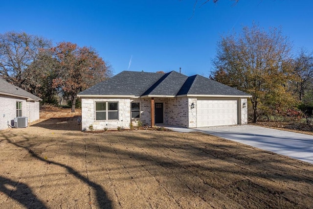 view of front of home featuring a garage, central AC, and a front lawn