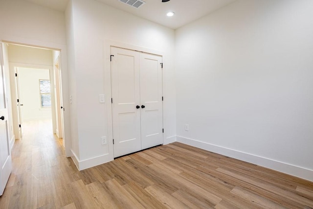 unfurnished bedroom with a closet and light hardwood / wood-style flooring