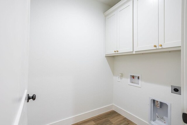 clothes washing area featuring hookup for an electric dryer, hookup for a washing machine, cabinets, gas dryer hookup, and hardwood / wood-style flooring