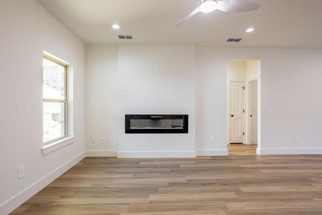 unfurnished living room featuring ceiling fan, a healthy amount of sunlight, and light hardwood / wood-style flooring