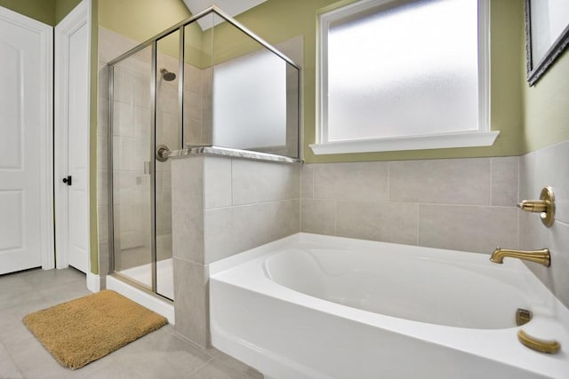 full bath featuring a garden tub, tile patterned flooring, and a shower stall