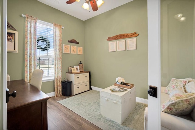 office area featuring baseboards, ceiling fan, and wood finished floors