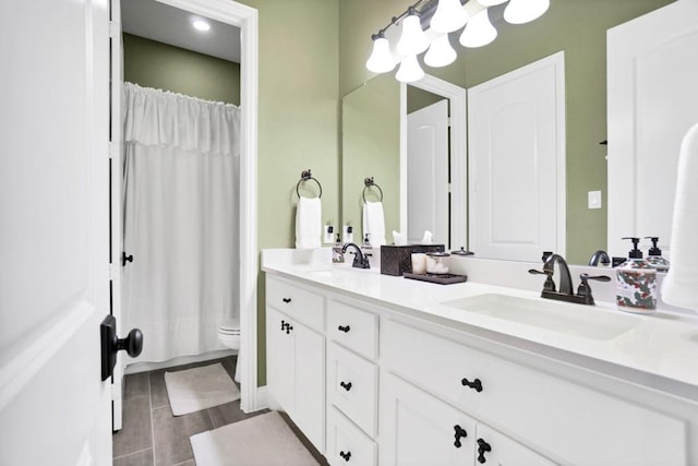 bathroom featuring double vanity, a sink, toilet, and a shower with curtain