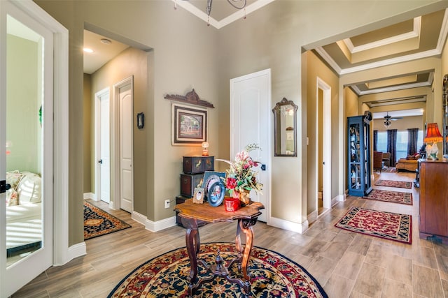 foyer entrance featuring baseboards, ornamental molding, and wood finish floors