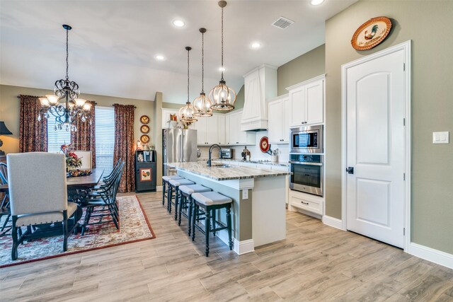 kitchen with visible vents, a sink, a chandelier, and stainless steel appliances
