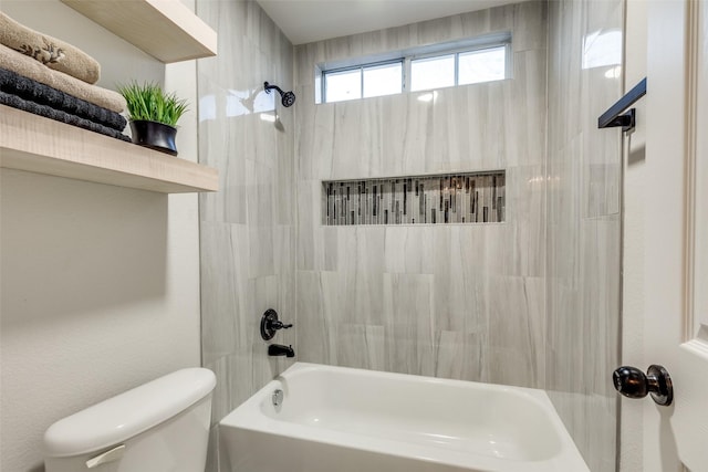 bathroom with tiled shower / bath combo and toilet