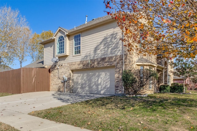 view of property featuring a garage and a front lawn