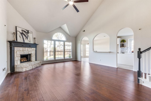 unfurnished living room with a fireplace, ceiling fan, hardwood / wood-style floors, and high vaulted ceiling