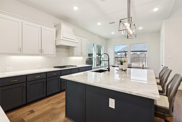 kitchen featuring pendant lighting, appliances with stainless steel finishes, white cabinetry, sink, and blue cabinetry