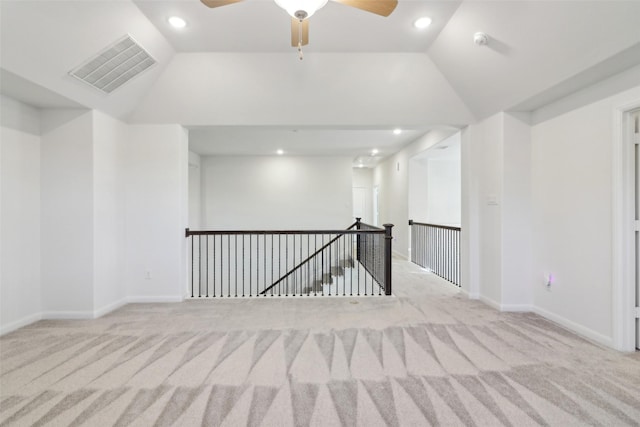 carpeted spare room with ceiling fan and lofted ceiling