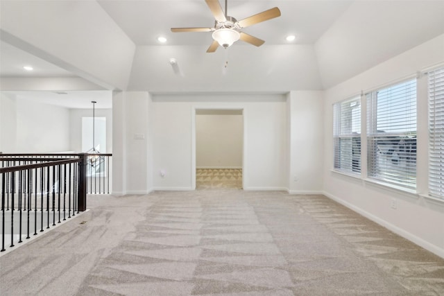 carpeted spare room with ceiling fan and vaulted ceiling