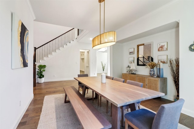 dining area with ornamental molding and dark hardwood / wood-style floors