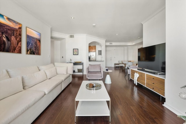 living room with crown molding and dark wood-type flooring