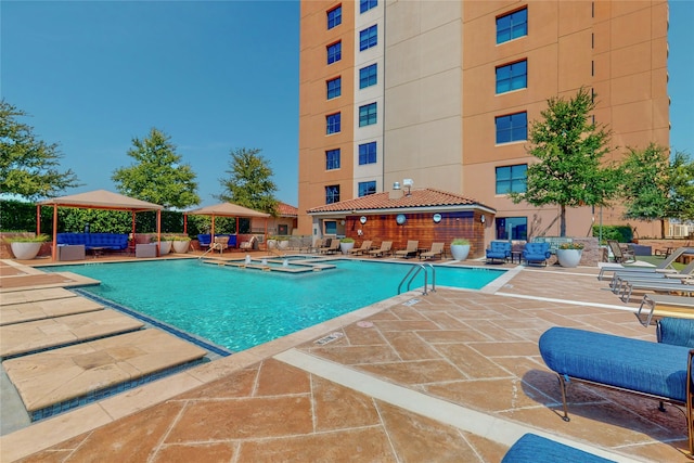 view of swimming pool featuring a gazebo, a community hot tub, and a patio area