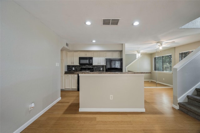 kitchen featuring ceiling fan, backsplash, light hardwood / wood-style floors, white cabinets, and black appliances