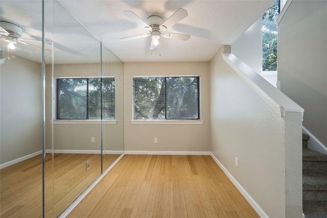 unfurnished bedroom featuring hardwood / wood-style floors, a closet, and ceiling fan