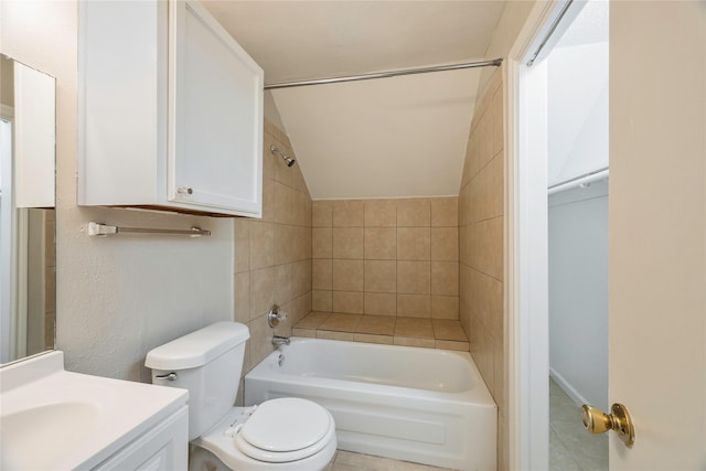 full bathroom featuring tile patterned floors, vanity, toilet, tiled shower / bath, and lofted ceiling