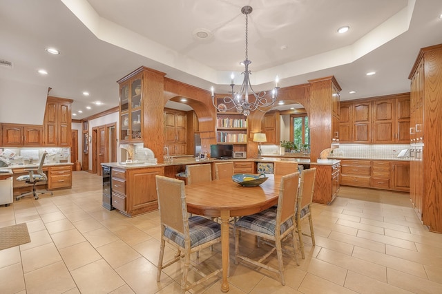 tiled dining area featuring a notable chandelier, a raised ceiling, and beverage cooler