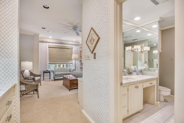 bathroom featuring vanity, toilet, ornamental molding, and ceiling fan with notable chandelier