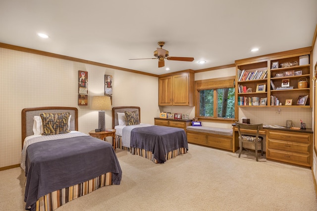 bedroom with ceiling fan, light carpet, built in desk, and ornamental molding