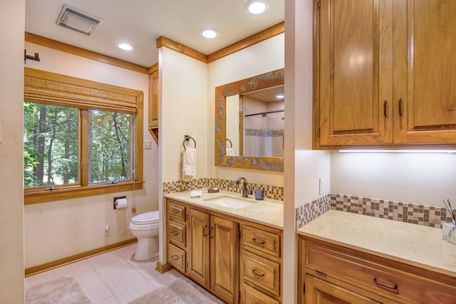 bathroom featuring vanity, toilet, and walk in shower