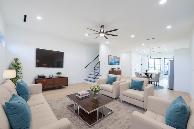 living room featuring ceiling fan and light hardwood / wood-style floors