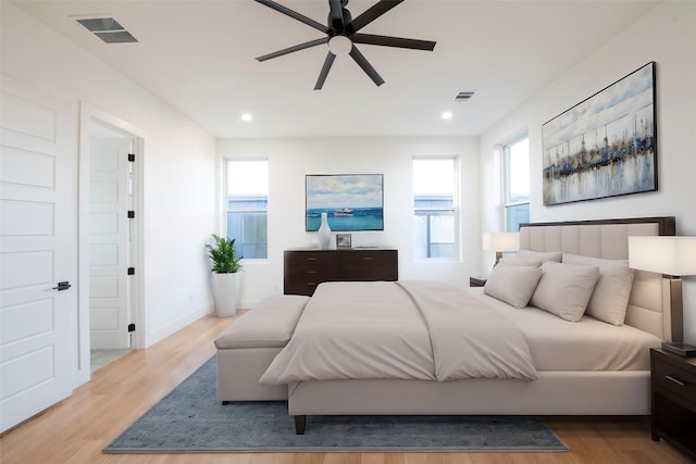 bedroom with ceiling fan, light wood-type flooring, and multiple windows