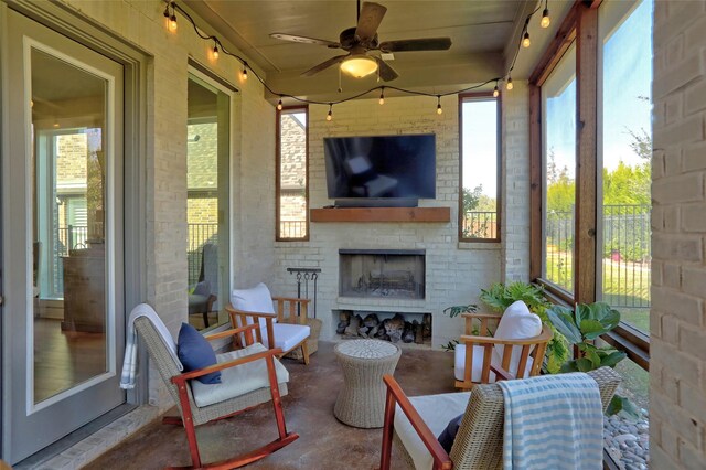 sunroom featuring an outdoor brick fireplace and ceiling fan