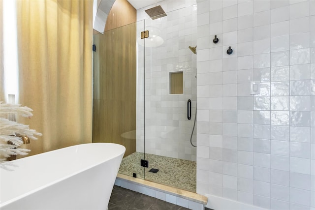 bathroom with a soaking tub, a shower stall, and tile patterned floors