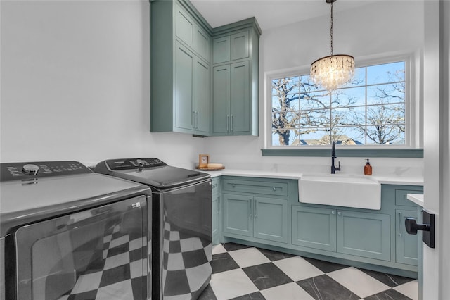 washroom featuring cabinets, washing machine and dryer, an inviting chandelier, and sink