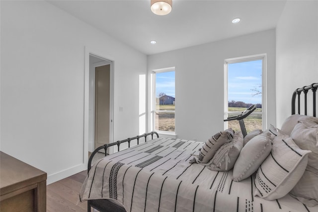 bedroom with light hardwood / wood-style flooring and multiple windows