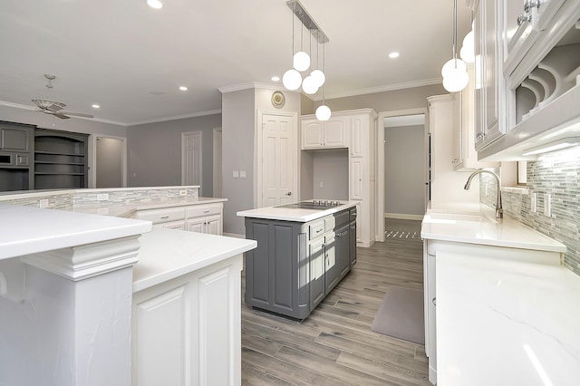 kitchen with gray cabinetry, a center island, sink, backsplash, and white cabinets