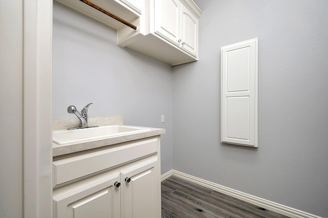 laundry room featuring dark hardwood / wood-style flooring and sink