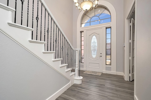 foyer entrance with a chandelier, a towering ceiling, and hardwood / wood-style flooring