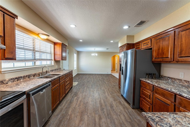 kitchen with stainless steel appliances, dark hardwood / wood-style flooring, sink, and a textured ceiling