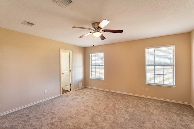 carpeted spare room featuring ceiling fan and a textured ceiling