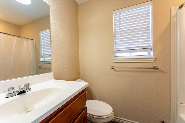 bathroom featuring vanity, curtained shower, and toilet